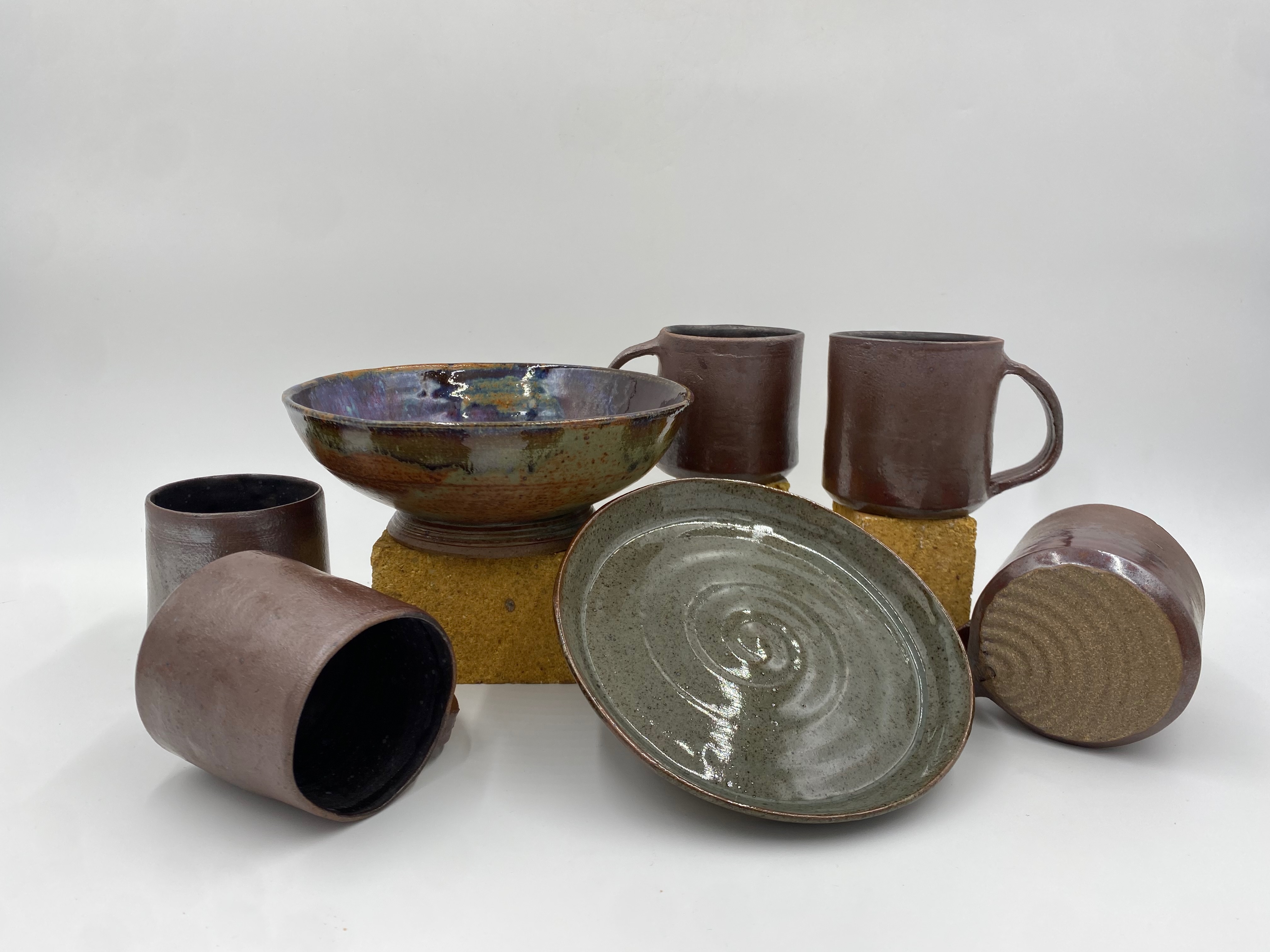 A collection of mugs, one bowl, and one plate.