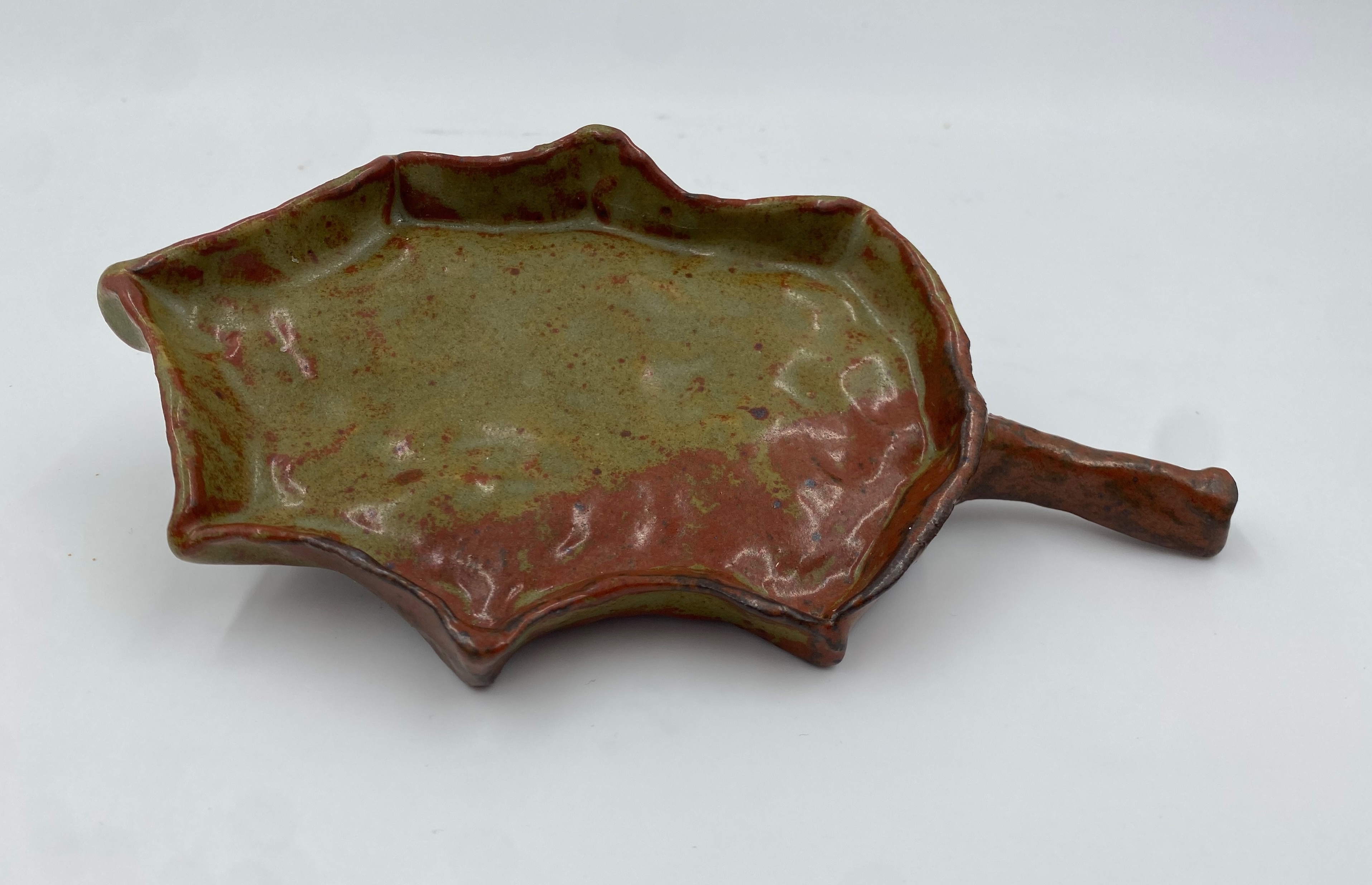 A small red-green oak leaf shaped dish.