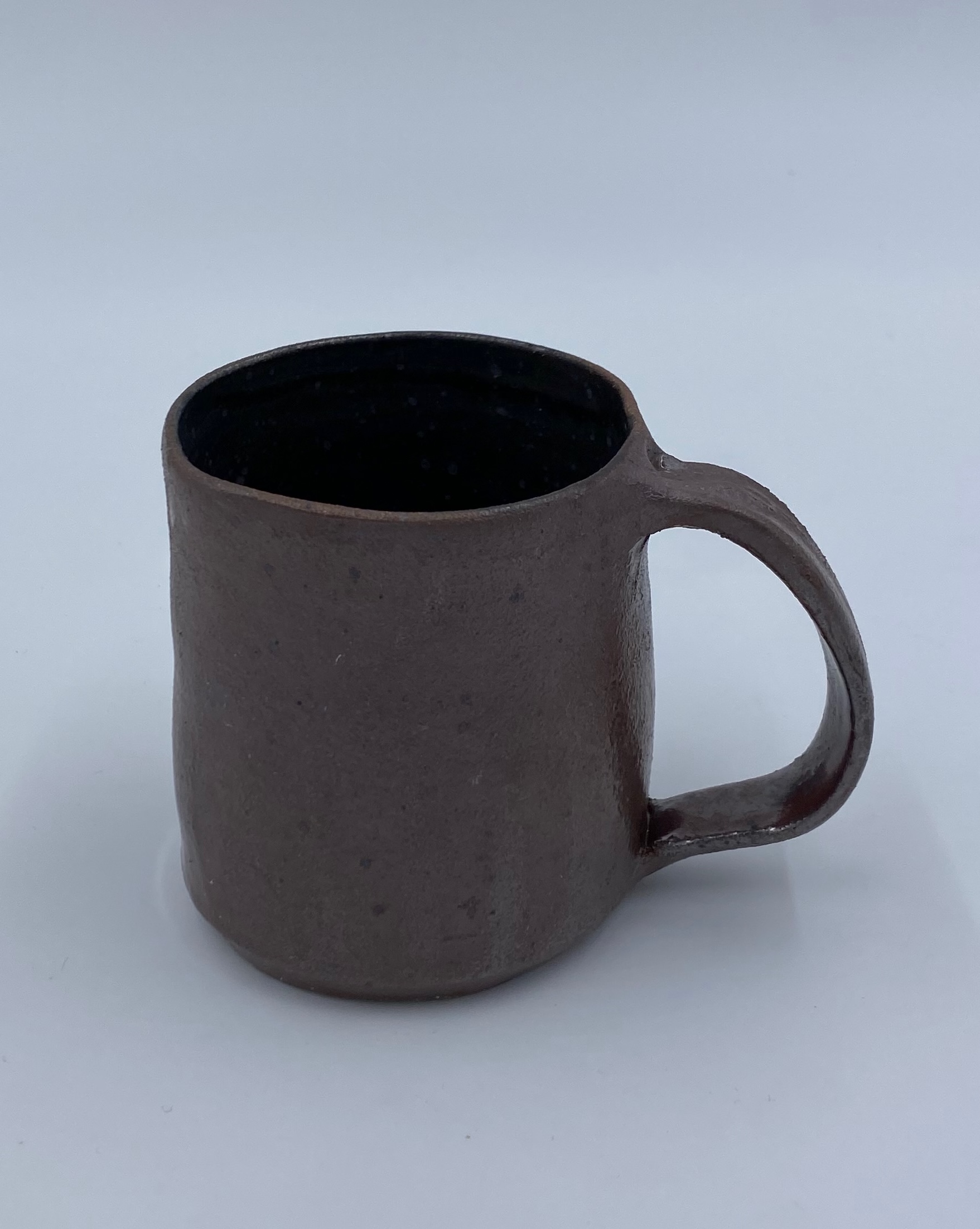 A metallic red mug with a black inner glaze.